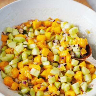 A bowl with mango salsa and cucumber.