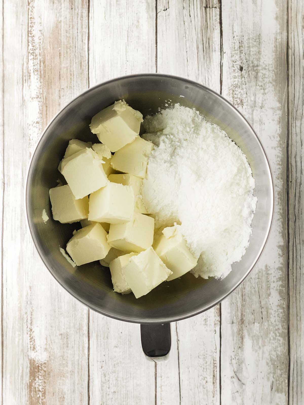 Butter and powdered sugar inside a mixing bowl.