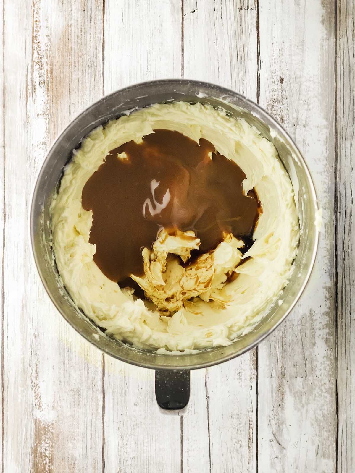 A mixing bowl with the creamy mixture and dulce de leche inside.