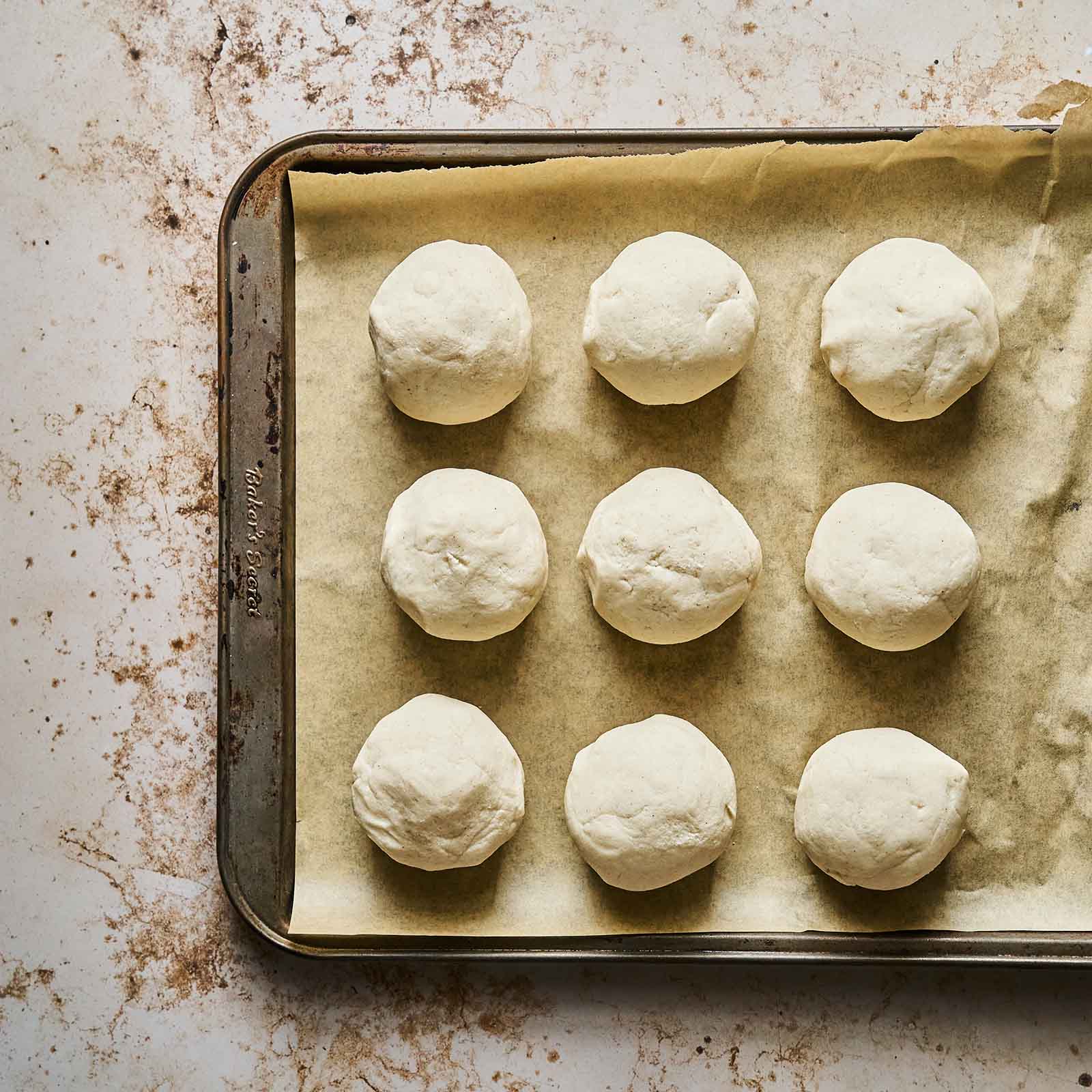 Masa shaped in balls placed on a baking tray with baking paper.