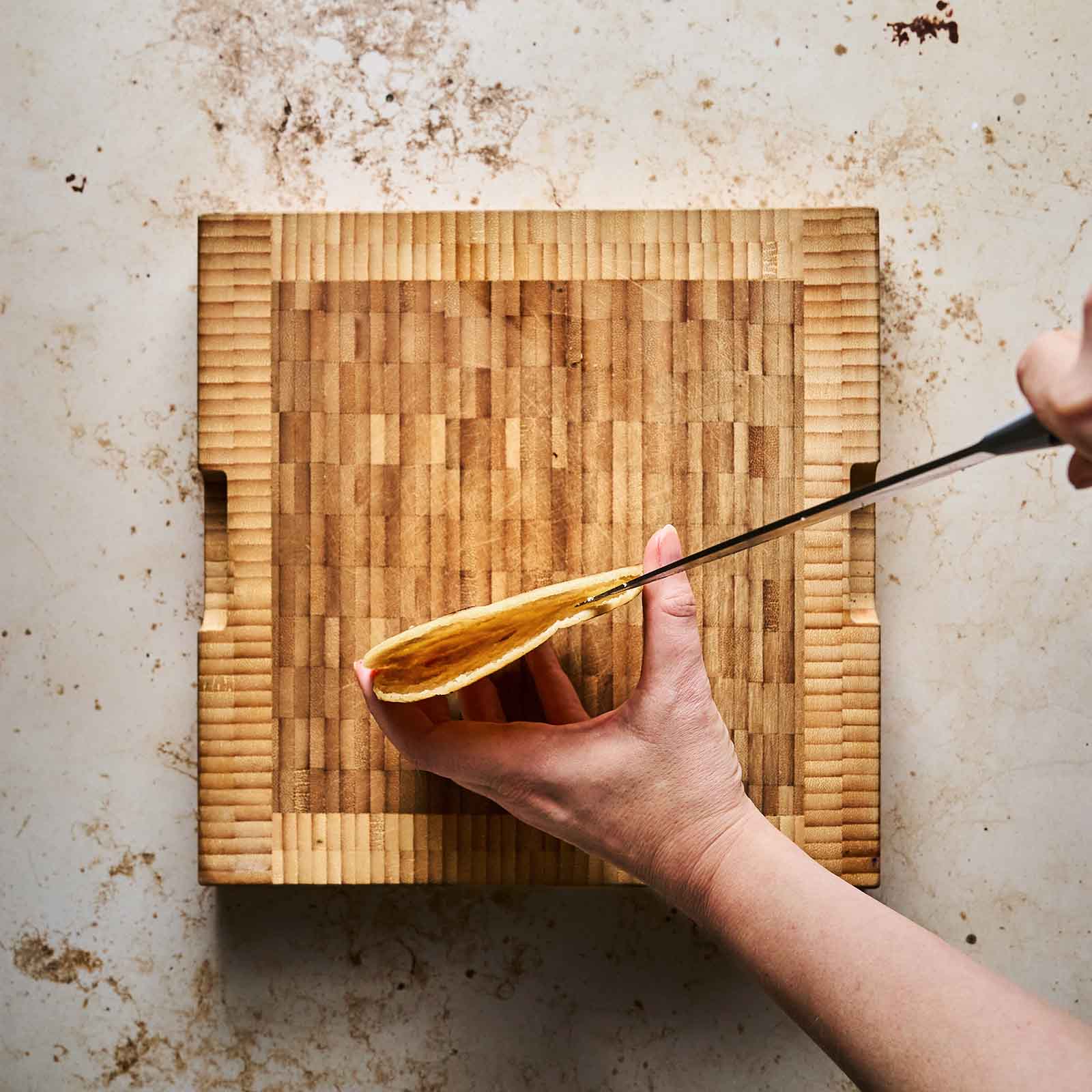 Freshly cooked gordita on a wooden cutting board with a chef's knife, ready to be served.