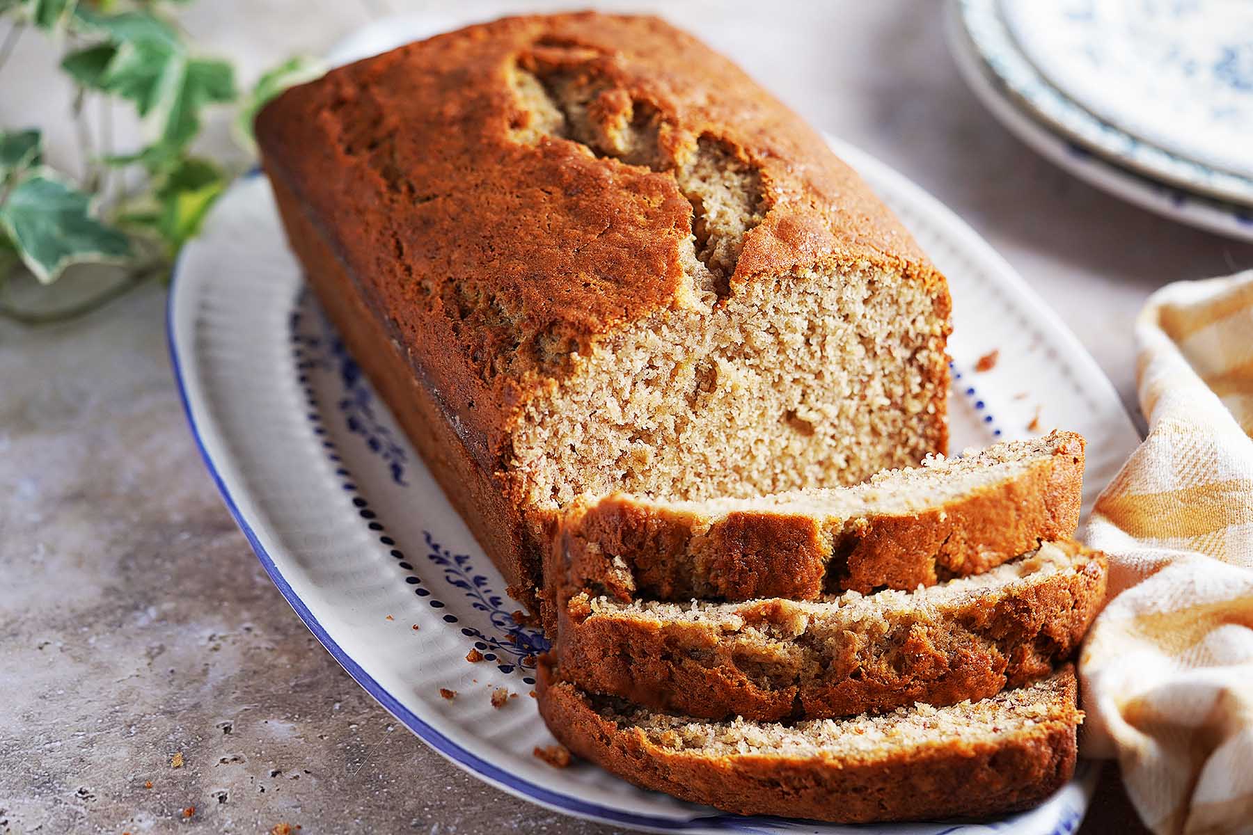 A loaf of Panqué de Plátano on a platter, with three slices cut from one end.